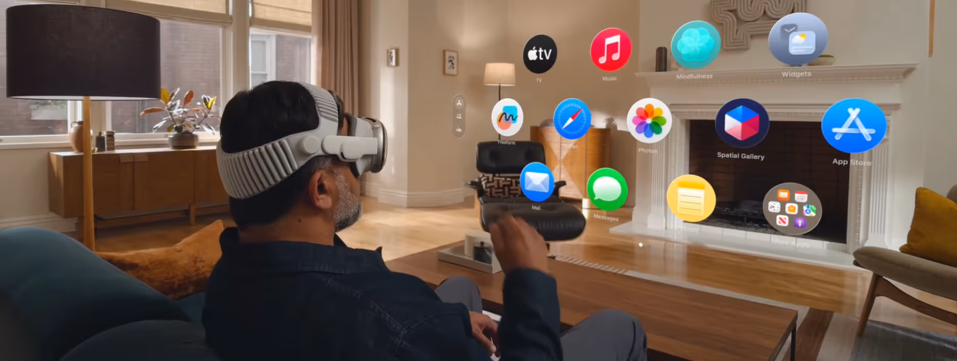 Man wearing VR headset using hand gestures to interact with virtual app icons in a living room.